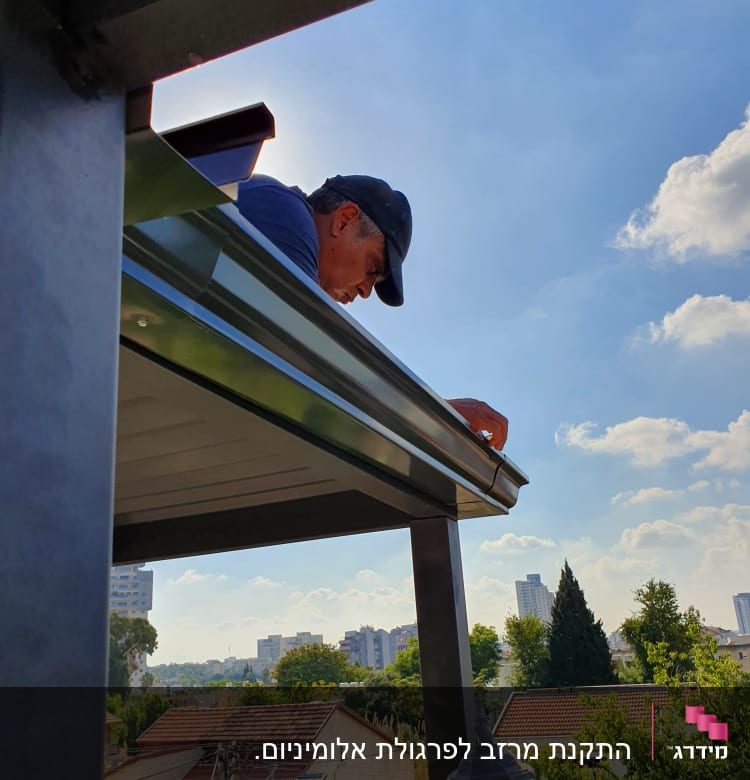 אדם עובד על גג עם כובע, שמיים בהירים